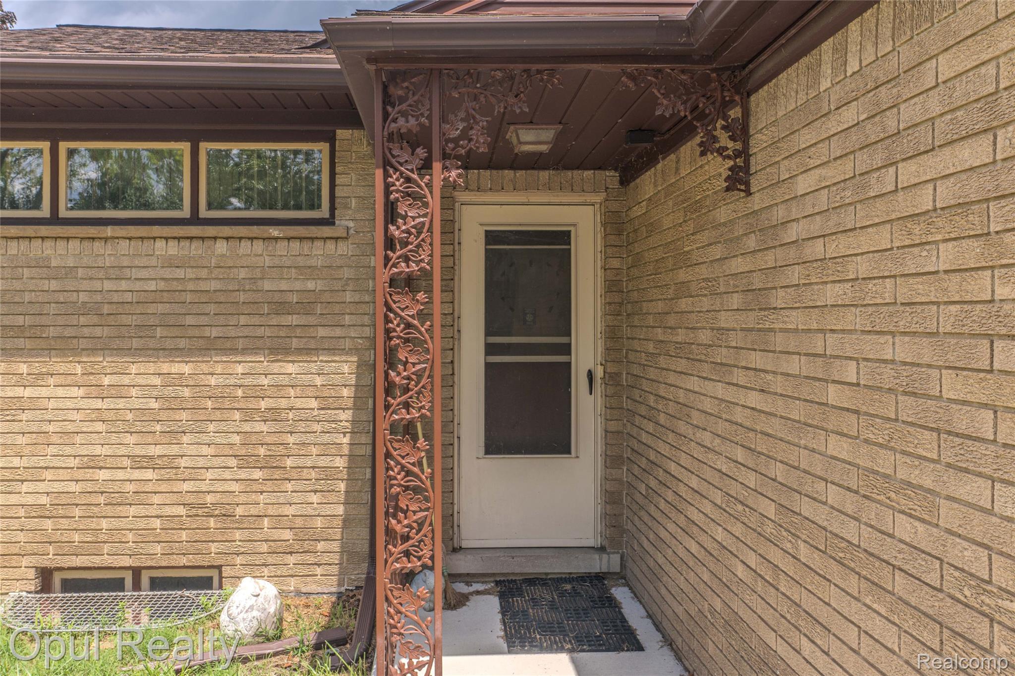 6455 Norham Road Bloomfield Hills, MI 48301 - Photo 23 of 93 Brick exterior with decorative wrought iron porch support and white entry door