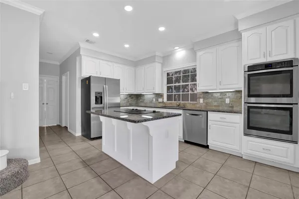 a kitchen with granite countertop a sink stove and refrigerator