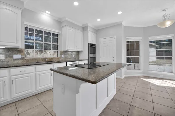 a kitchen with granite countertop a sink stove and refrigerator