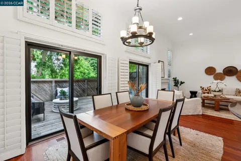 a view of a dining room with furniture a chandelier and wooden floor