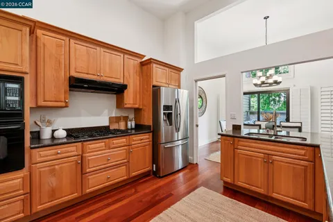 a kitchen with granite countertop a table chairs stove and cabinets