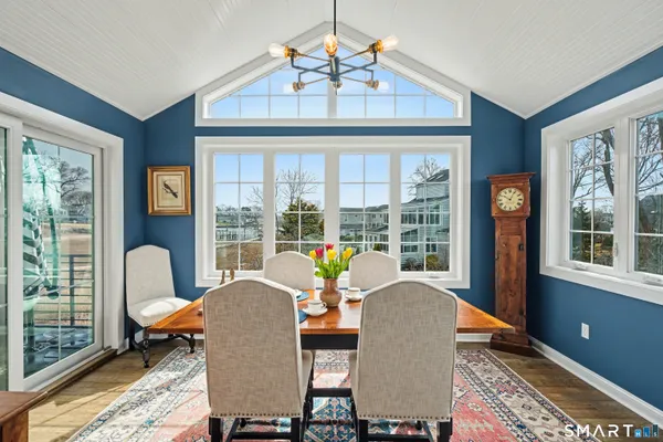 a dining room with furniture a chandelier and wooden floor