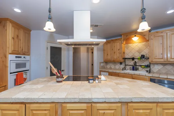a kitchen with stainless steel appliances granite countertop a sink a stove and a wooden floors