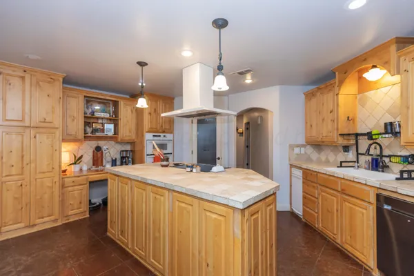 a kitchen with a sink a counter space appliances and cabinets