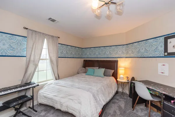 a bed room with a bed and a chair