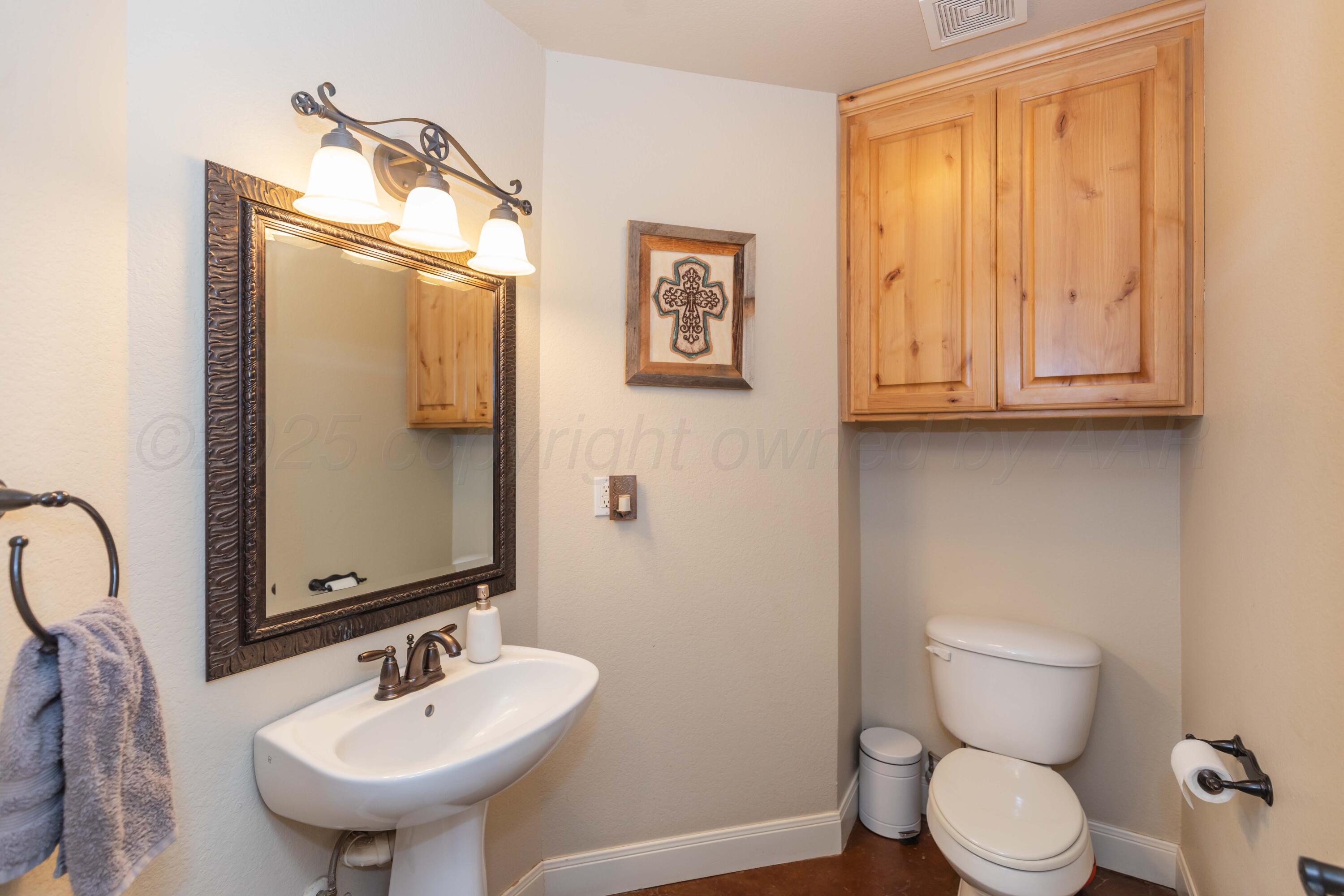 1301 Moon Ridge Lane Amarillo, TX 79124 - Photo 33 of 34 a bathroom with a toilet sink and mirror