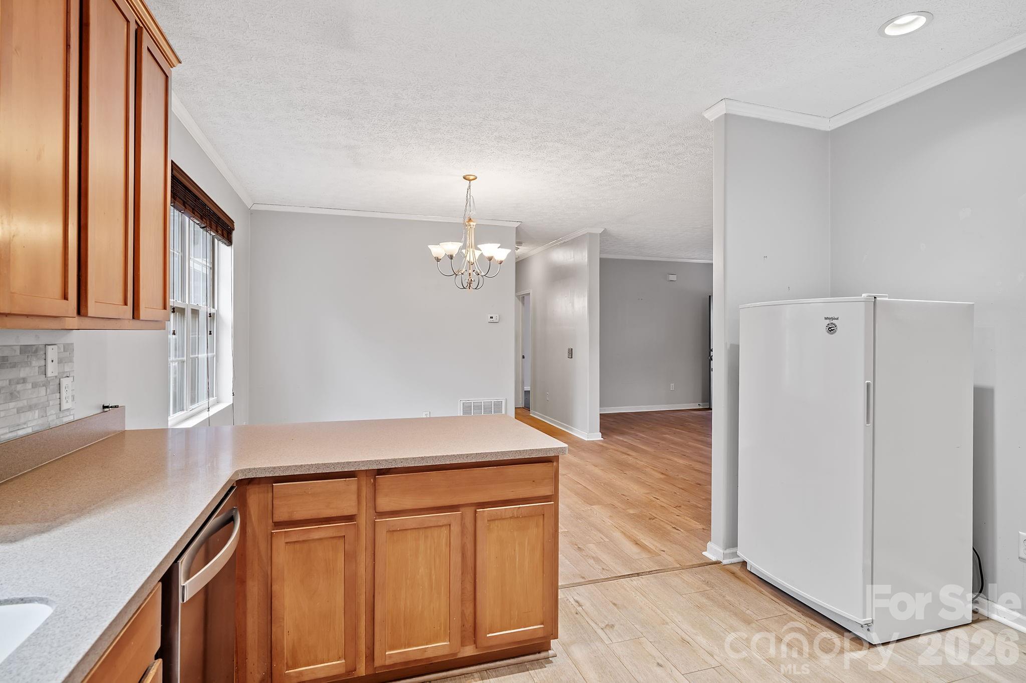 60 Maple Ridge Drive Old Fort, NC 28762 - Photo 11 of 42 a kitchen with stainless steel appliances granite countertop a refrigerator a sink dishwasher and white cabinets with wooden floor
