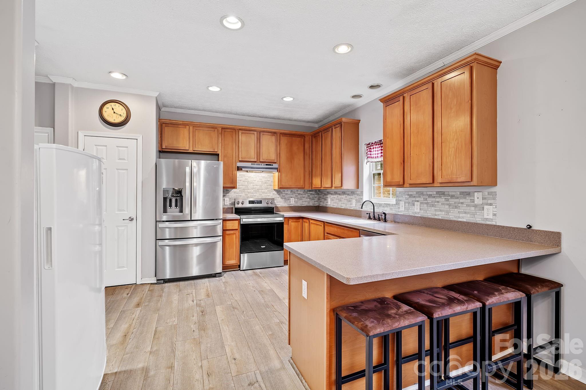 60 Maple Ridge Drive Old Fort, NC 28762 - Photo 8 of 42 a kitchen with stainless steel appliances granite countertop a refrigerator a sink dishwasher a stove and white countertops with wooden floor
