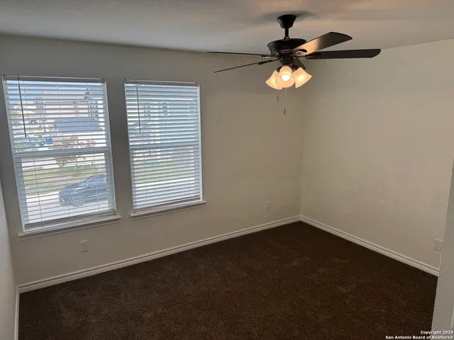 an empty room with a ceiling fan and a window
