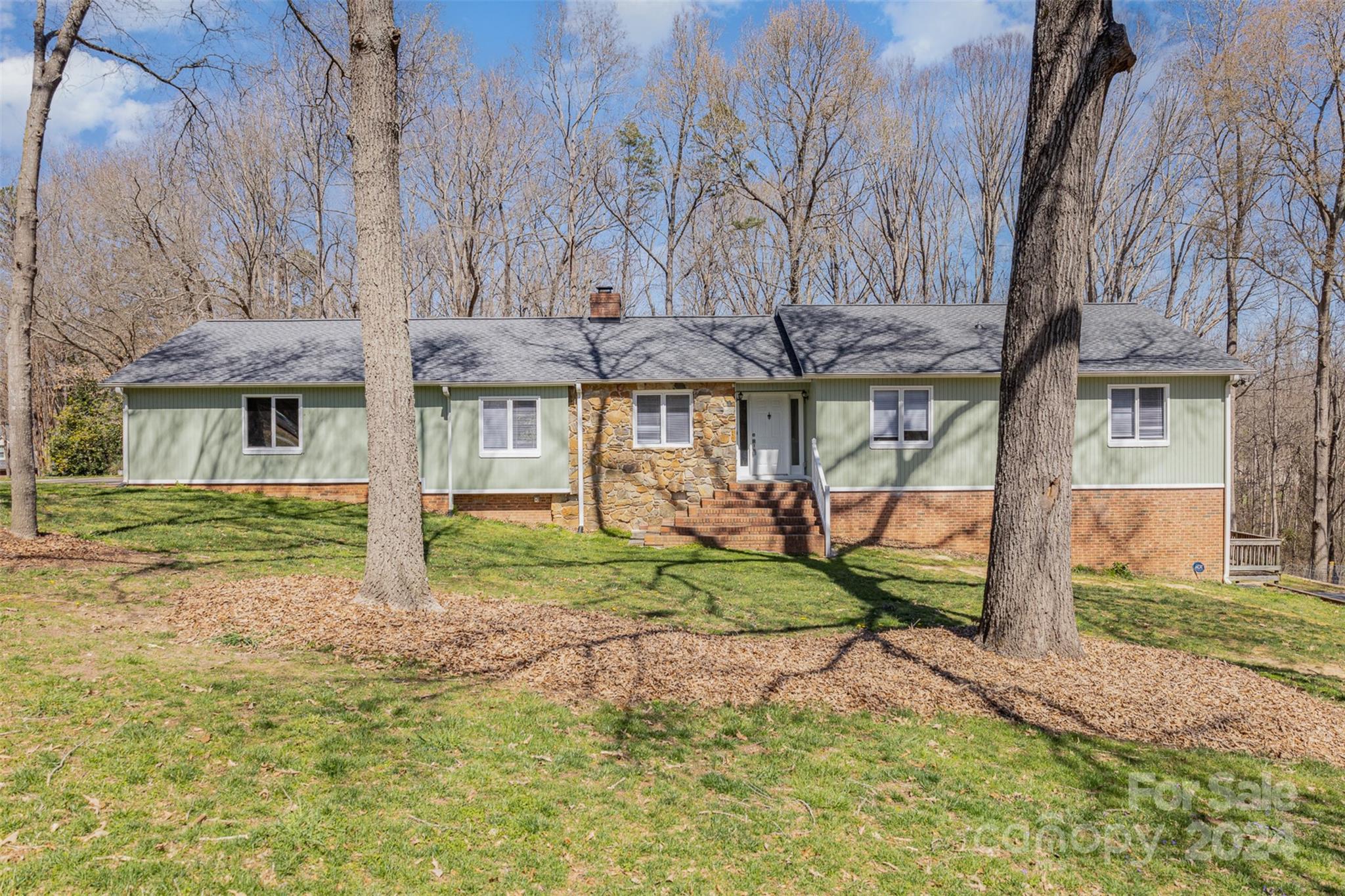 1704 Double Oaks Road Fort Mill, SC 29715 - Photo 1 of 48 a yellow house with trees in front of it