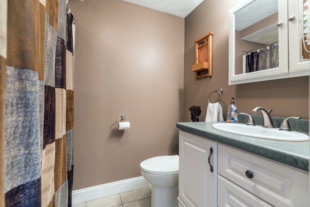 151 Killam Hill Road Boxford, MA 01921 - Photo 16 of 30 a bathroom with a granite countertop toilet sink and mirror