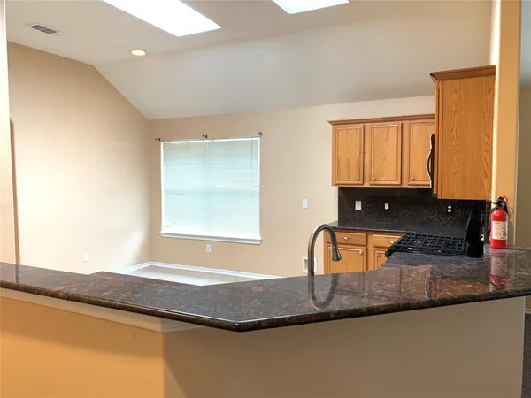 a bathroom with granite countertop a sink and a window