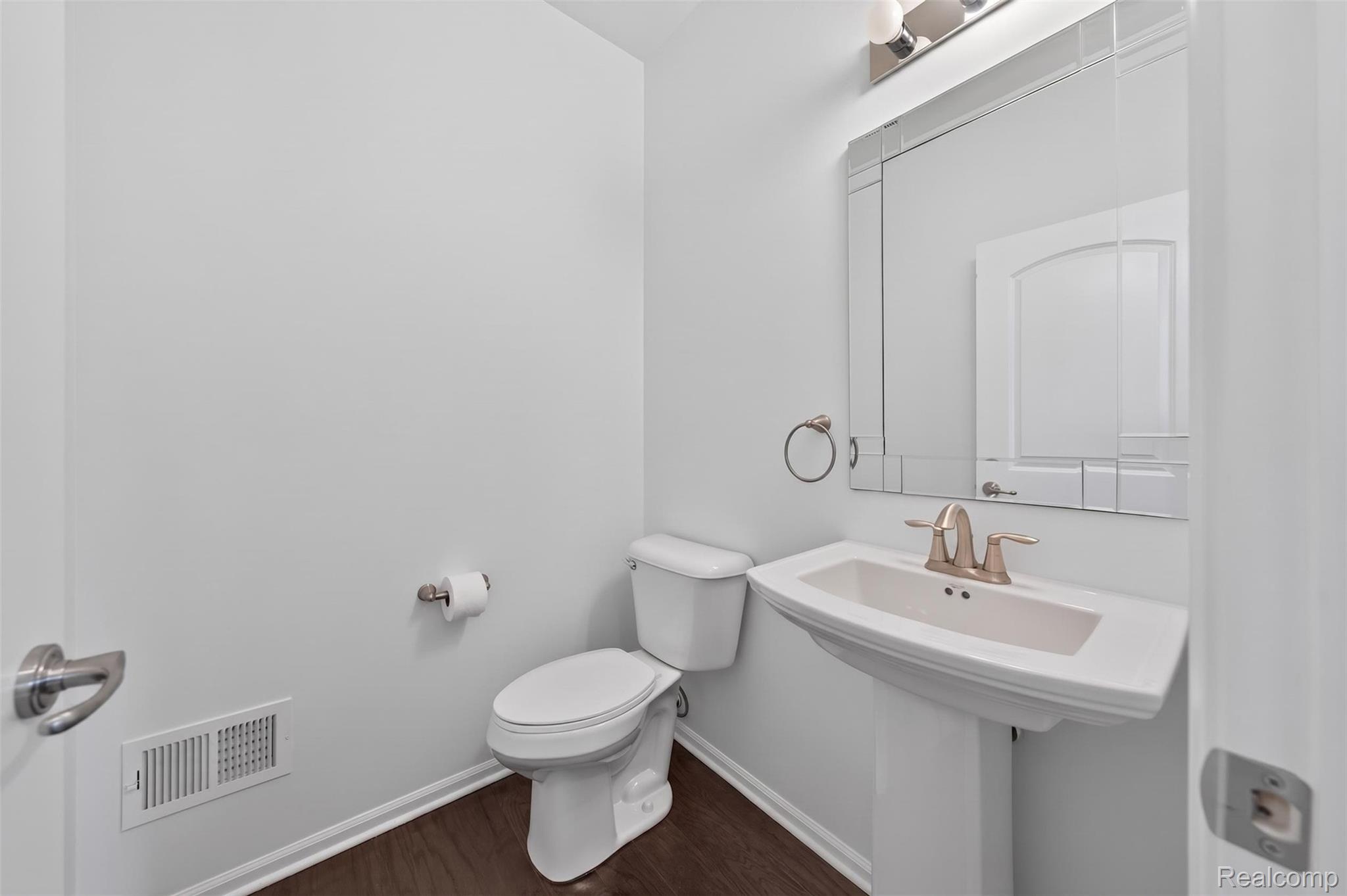 3534 South Rochester Road Royal Oak, MI 48073 - Photo 13 of 25 Pedestal sink with brushed nickel faucet, framed decorative mirror, and coordinating vanity light fixture