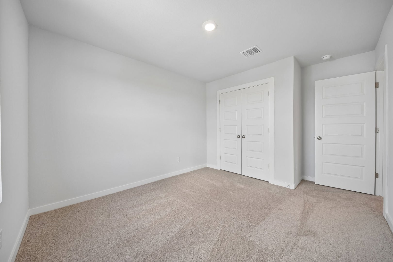 145 Hornet Street Elgin, TX 78621 - Photo 3 of 18 A well-lit bedroom features plush carpeting and convenient closet access.
