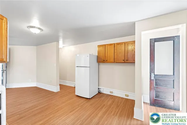 a kitchen with stainless steel appliances granite countertop a refrigerator a sink dishwasher and a fireplace with wooden floor