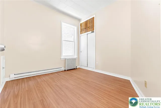 an empty room with window and wooden floor
