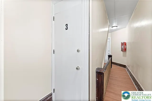 a kitchen with wooden floors and white cabinets