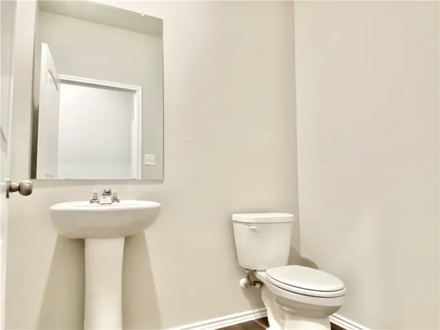 a bathroom with a sink mirror and a toilet