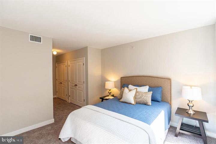 616 E Street Northwest, Unit 655 Washington, DC 20004 - Photo 21 of 38 a bedroom with a bed and a lamp