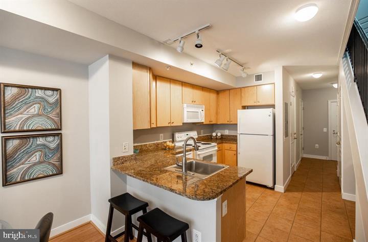 616 E Street Northwest, Unit 655 Washington, DC 20004 - Photo 7 of 38 a kitchen with stainless steel appliances granite countertop a sink refrigerator and cabinets