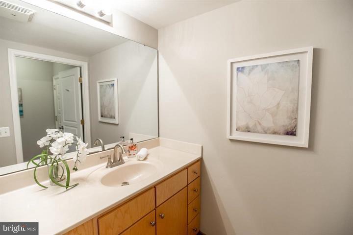 616 E Street Northwest, Unit 655 Washington, DC 20004 - Photo 10 of 38 a bathroom with a sink mirror and vanity