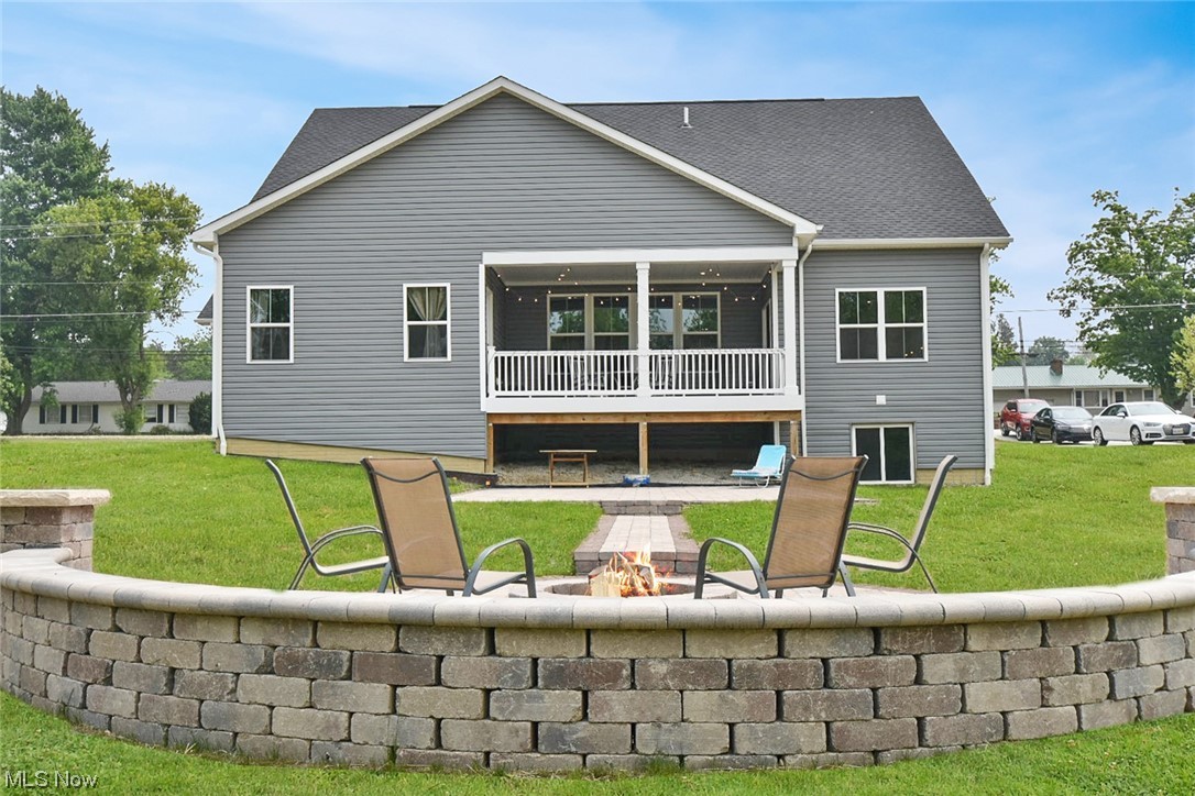 6334 Ryan Road Medina, OH 44256 - Photo 31 of 32 Rear view of house with a lawn and an outdoor fire pit