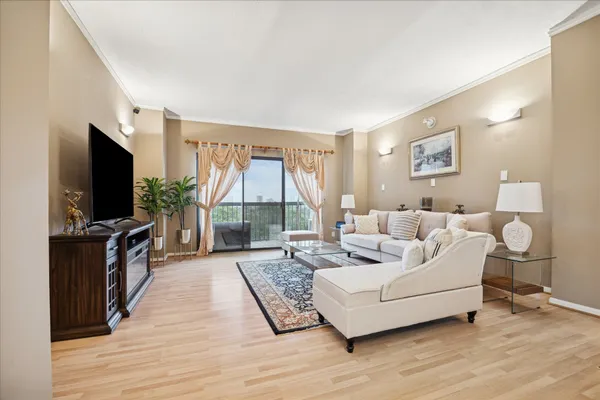 a living room with furniture a flat screen tv and a large window
