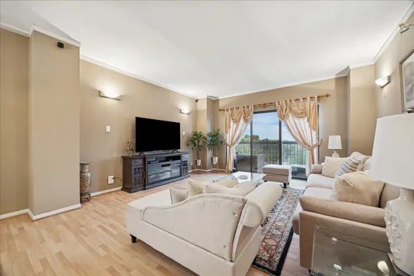 a living room with furniture a flat screen tv and a large window