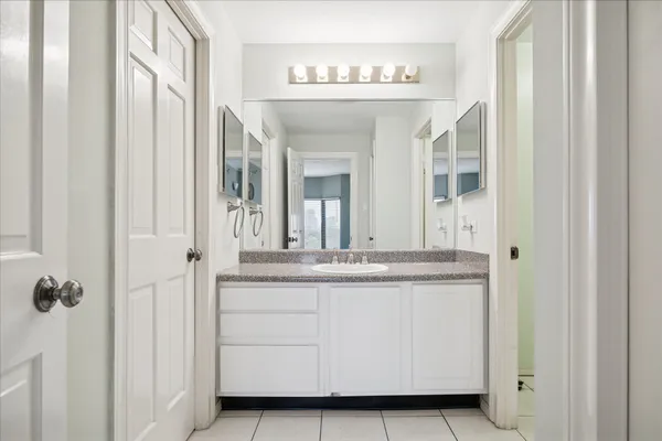a bathroom with a granite countertop sink and a mirror