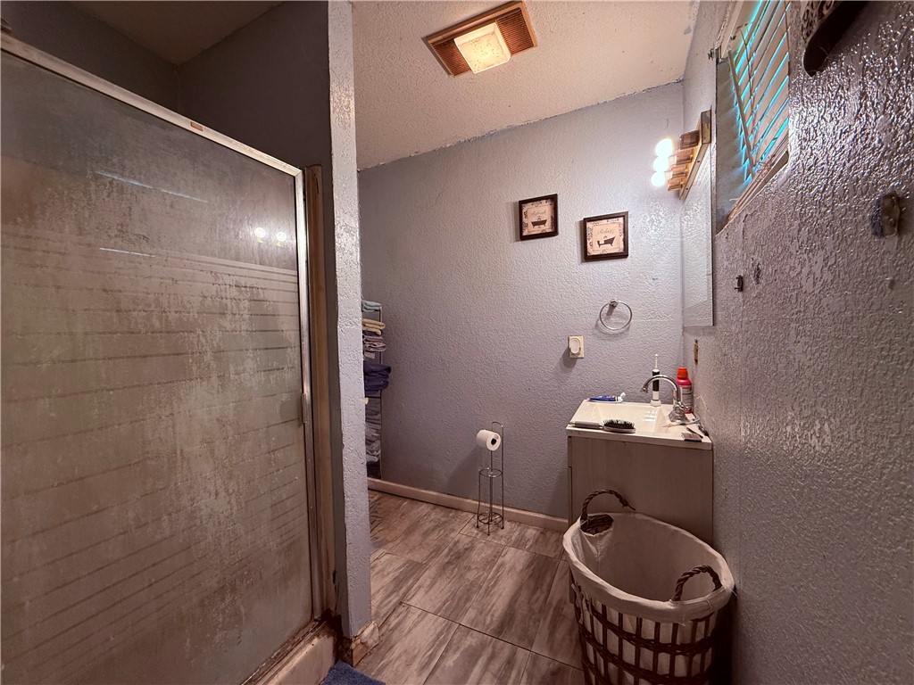 5742 Hidden Valley Loop Sandia, TX 78383 - Photo 11 of 27 a bathroom with a granite countertop sink a mirror and wooden floor