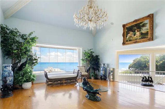 a living room with furniture floor to ceiling window and a flat screen tv