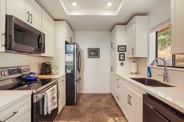 a kitchen with stainless steel appliances a stove sink microwave and cabinets