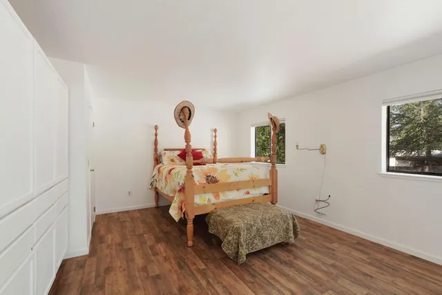 a bedroom with a bed a mirror and a window