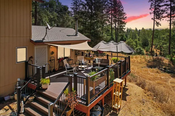a view of a patio with table and chairs with wooden floor and fence