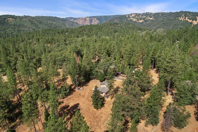 a view of a wooden house with a snow on the road