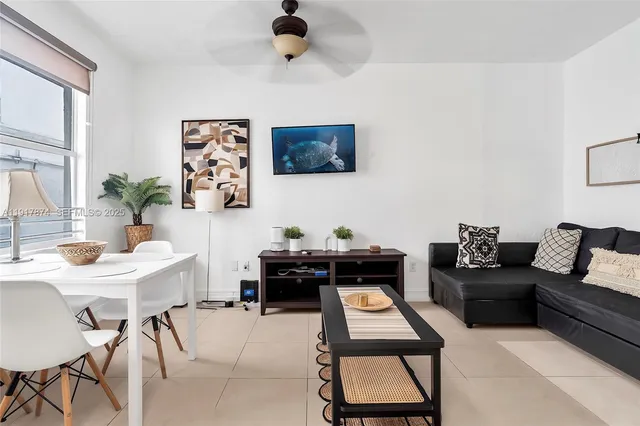 a living room with furniture a flat screen tv and a window