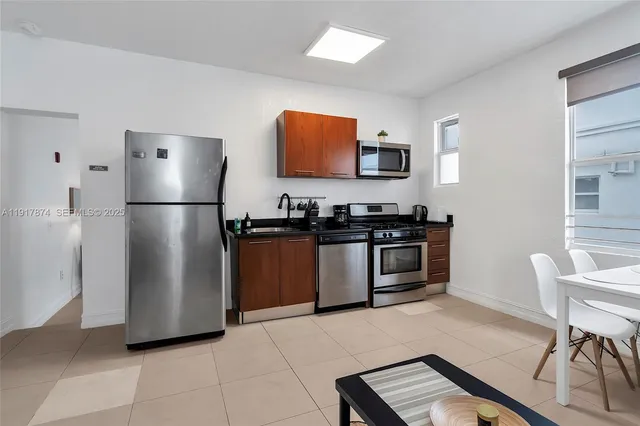 a kitchen with granite countertop a refrigerator and a stove top oven