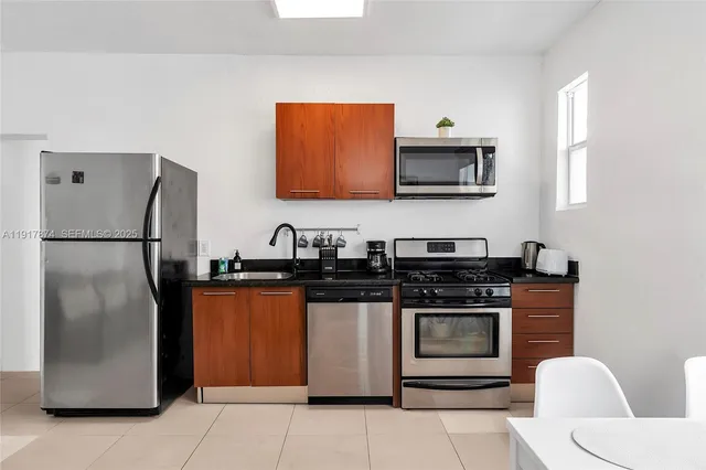 a kitchen with stainless steel appliances granite countertop a stove a refrigerator and a sink
