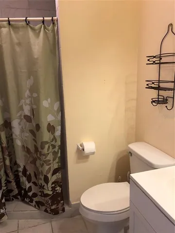 a white toilet sitting next to a shower curtain