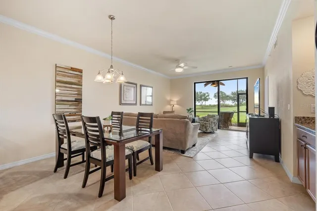 a view of a dining room and livingroom with furniture large windows a chandelier