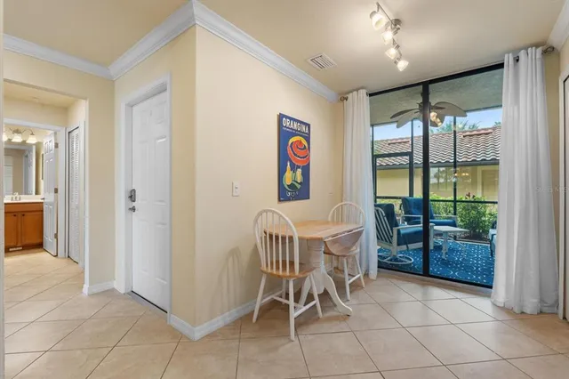 a dining room with furniture and a floor to ceiling window