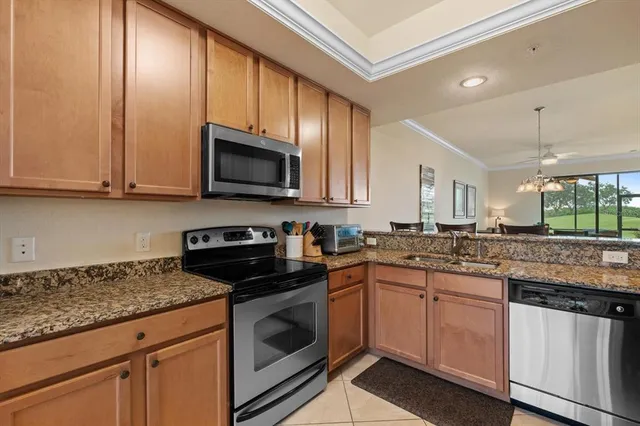 a kitchen with granite countertop wooden cabinets and a stove top oven