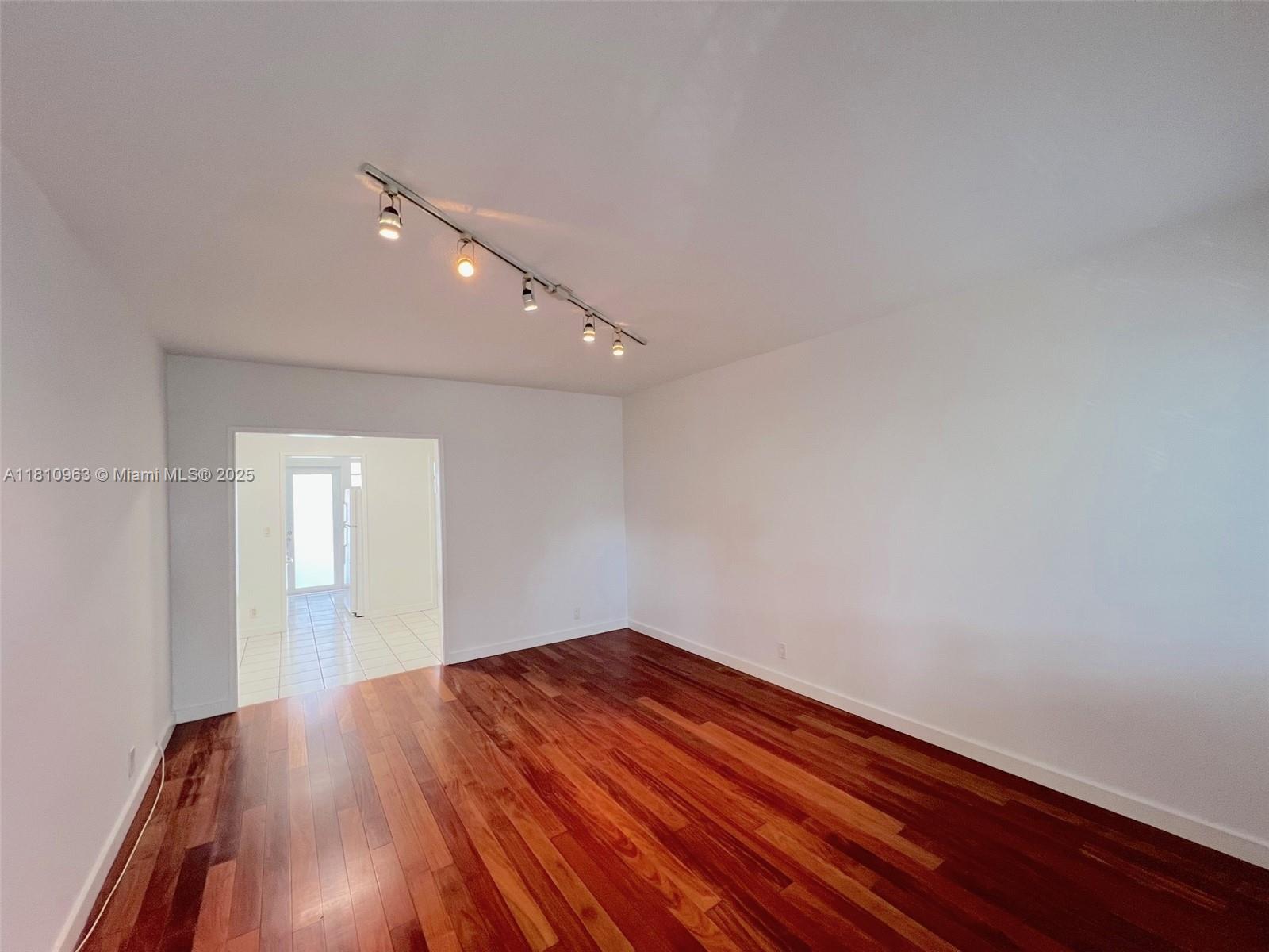 a view of empty room with wooden floor