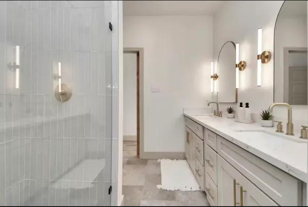 a bathroom with a double vanity sink mirror and shower
