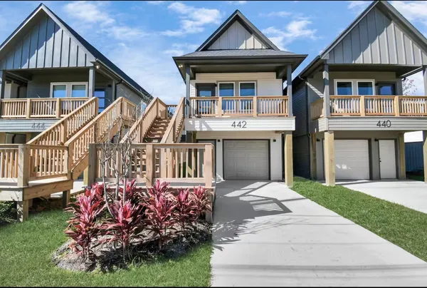 a front view of a house with a garden and deck