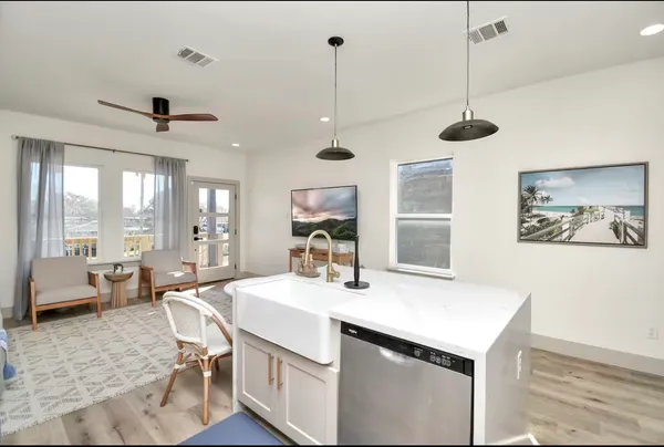 a room with a chandelier a sink and a large window