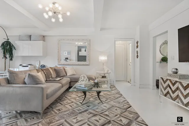 a living room with furniture and a large mirror with wooden floor