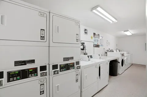 a view of a kitchen with stainless steel appliances and white cabinets