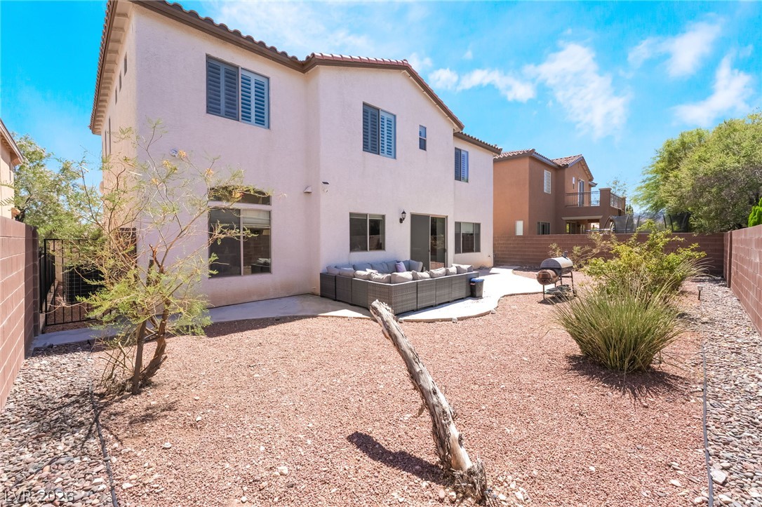 8358 Nelson Ridge Lane Las Vegas, NV 89178 - Photo 40 of 43 A spacious backyard with a large patio and a low-maintenance gravel landscape.