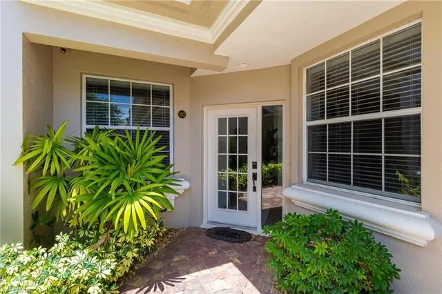 a view of front door with potted plant in front of house